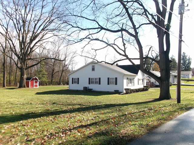 view of home's exterior featuring a lawn and a storage unit