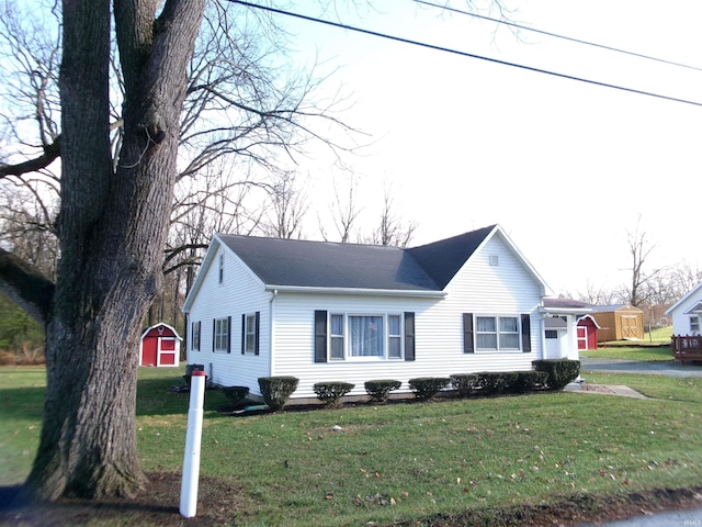 view of front facade featuring a front lawn and a storage unit