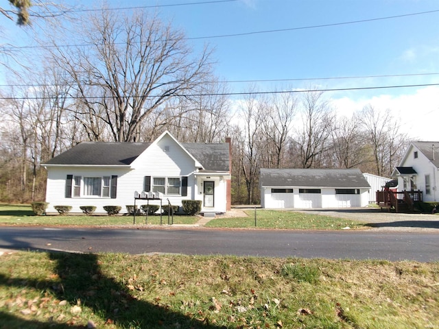 view of front facade featuring an outbuilding, a front yard, and a garage