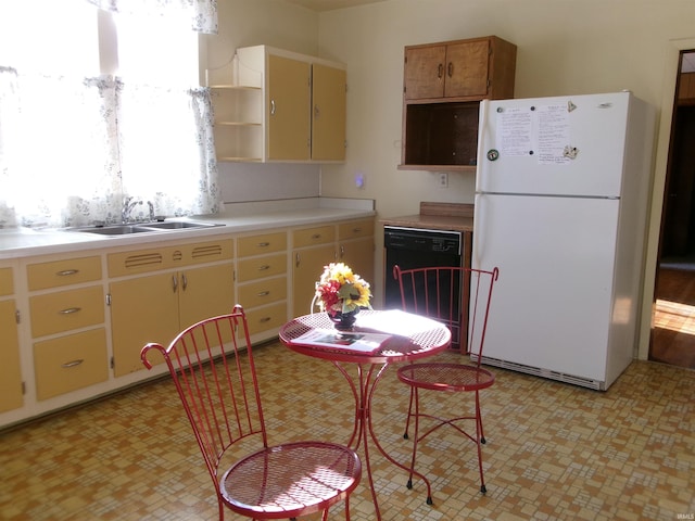 kitchen featuring dishwasher, white fridge, and sink