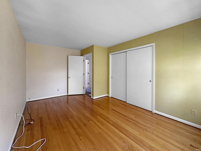 unfurnished bedroom featuring light hardwood / wood-style floors and a closet