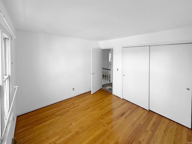 unfurnished bedroom with a closet and hardwood / wood-style floors