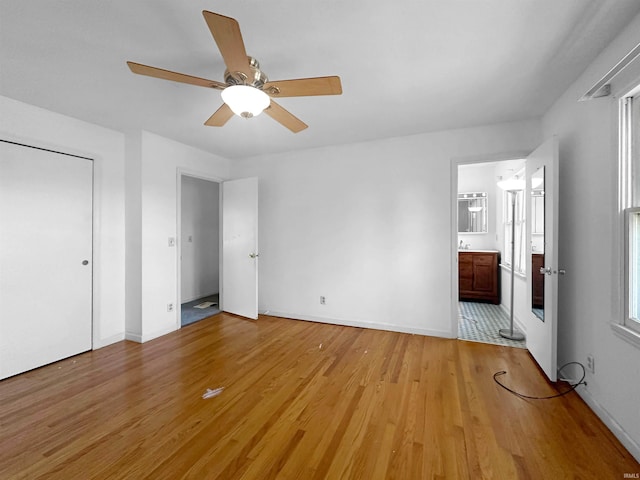 unfurnished bedroom with light hardwood / wood-style floors, ceiling fan, and ensuite bathroom