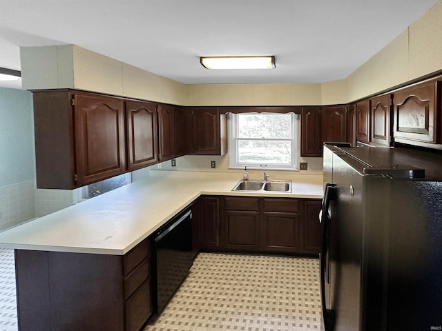 kitchen featuring kitchen peninsula, dark brown cabinetry, sink, black dishwasher, and stainless steel refrigerator