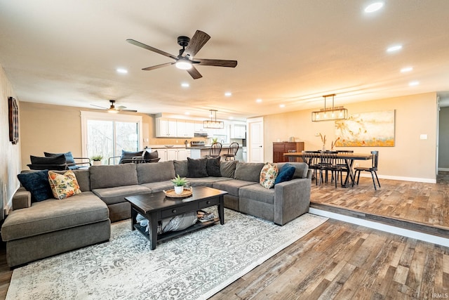 living room featuring ceiling fan and light wood-type flooring