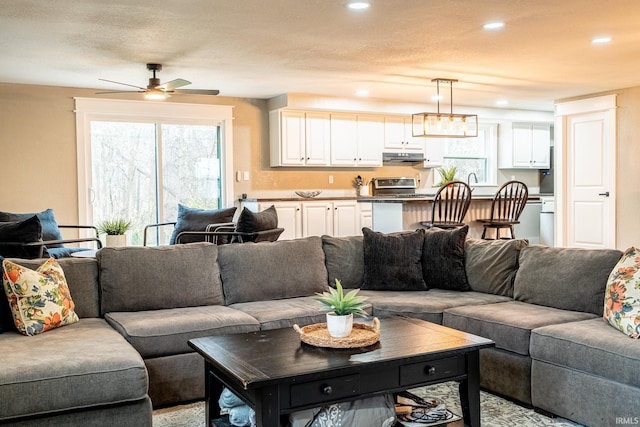 living room featuring a textured ceiling and ceiling fan