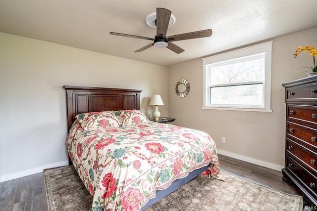 bedroom with ceiling fan, dark hardwood / wood-style flooring, and a textured ceiling