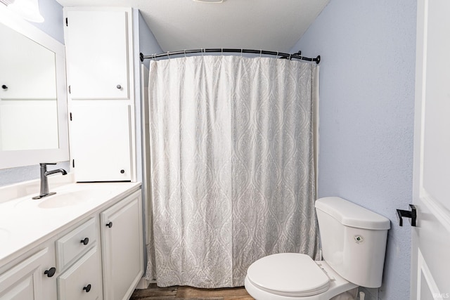 bathroom with hardwood / wood-style floors, vanity, and toilet