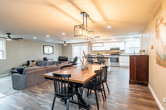 dining space with ceiling fan and dark wood-type flooring