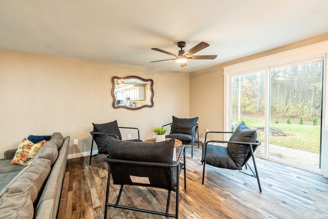 living area featuring ceiling fan, a textured ceiling, and hardwood / wood-style flooring