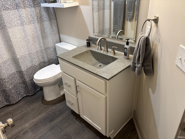 bathroom with hardwood / wood-style floors, vanity, toilet, and a shower with curtain