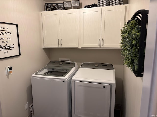 washroom featuring cabinets and separate washer and dryer