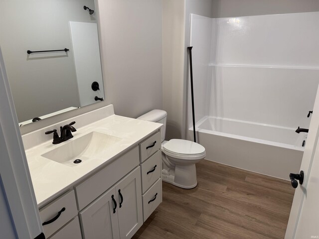 bathroom with toilet, shower / tub combination, vanity, and wood finished floors