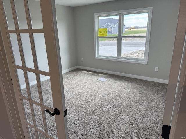 carpeted spare room with baseboards