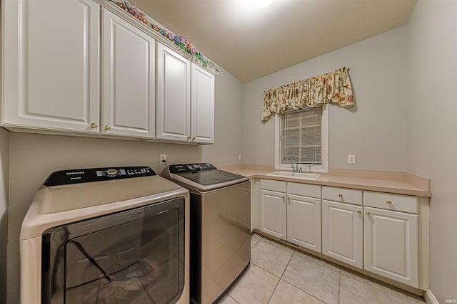 clothes washing area with cabinets, sink, light tile patterned flooring, and washer and dryer