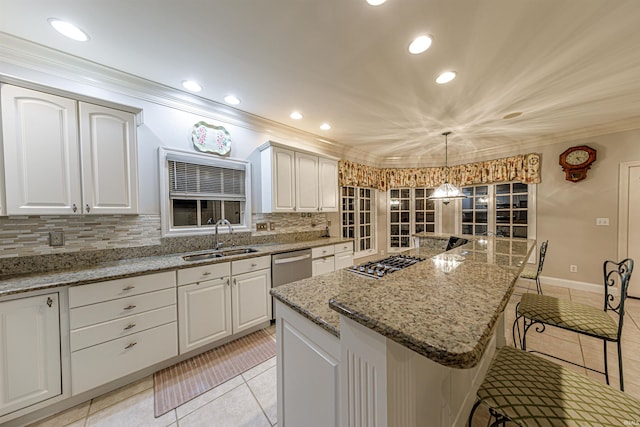 kitchen featuring white cabinets, decorative light fixtures, a center island, and sink