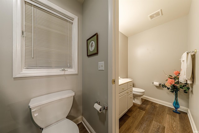 bathroom with toilet, vanity, and hardwood / wood-style flooring