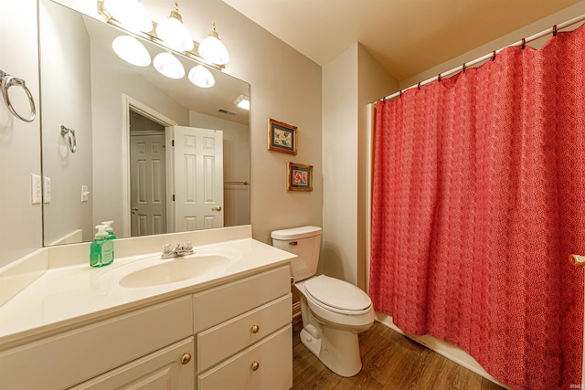 bathroom featuring wood-type flooring, vanity, and toilet