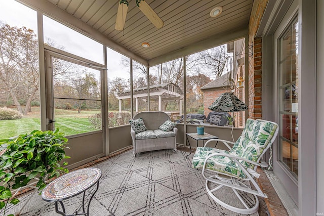 sunroom with ceiling fan and wooden ceiling