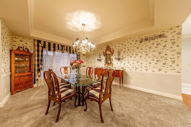 carpeted dining room with an inviting chandelier, crown molding, and a tray ceiling