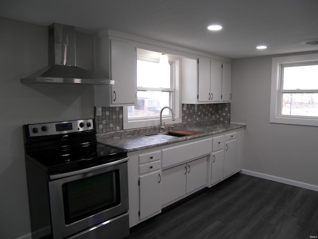 kitchen featuring backsplash, wall chimney exhaust hood, sink, electric range, and white cabinetry