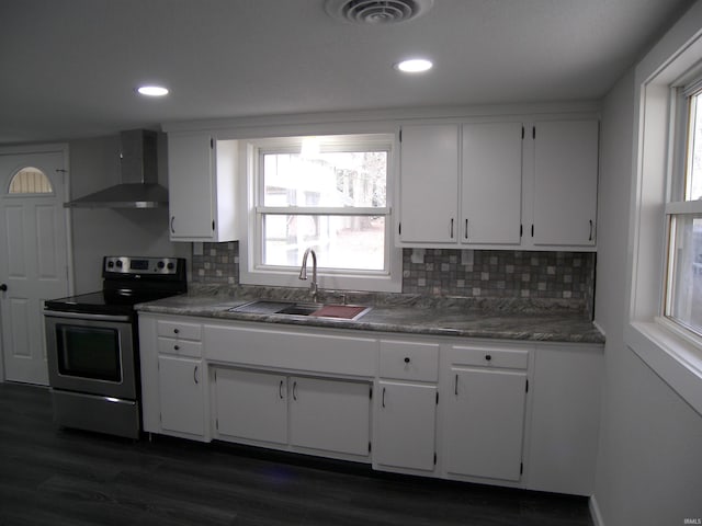 kitchen featuring stainless steel electric stove, white cabinets, sink, wall chimney exhaust hood, and decorative backsplash