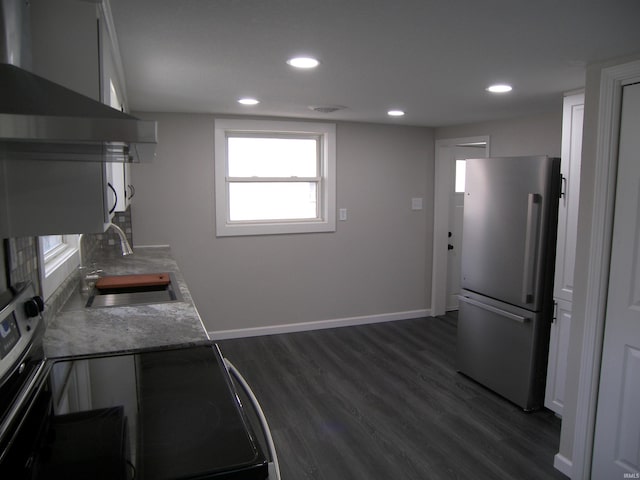 kitchen with appliances with stainless steel finishes, dark hardwood / wood-style flooring, white cabinetry, and sink