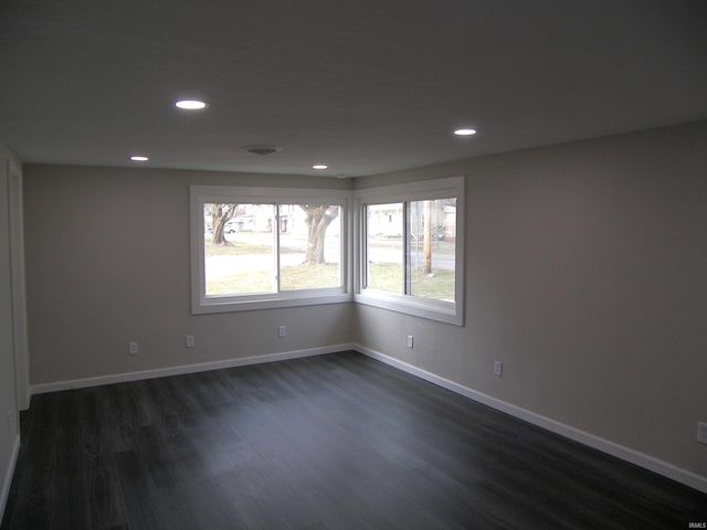 unfurnished room with dark wood-type flooring