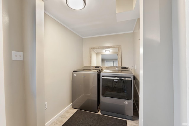 laundry room featuring separate washer and dryer, crown molding, and light hardwood / wood-style floors