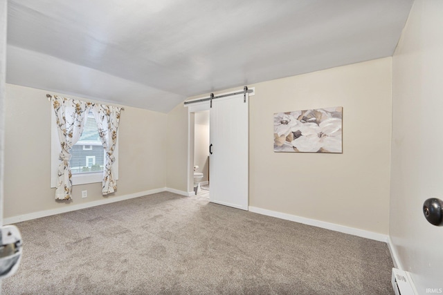 carpeted spare room featuring a barn door, lofted ceiling, and baseboard heating