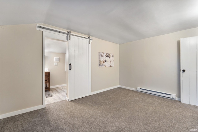 empty room featuring carpet, a barn door, vaulted ceiling, and a baseboard heating unit