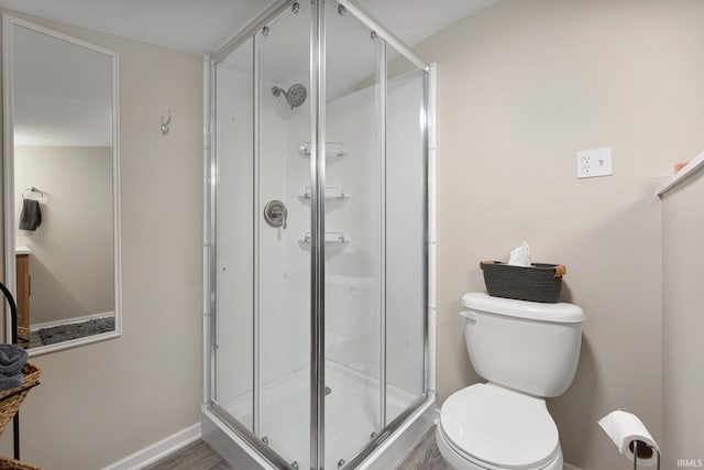 bathroom featuring hardwood / wood-style floors, toilet, and an enclosed shower