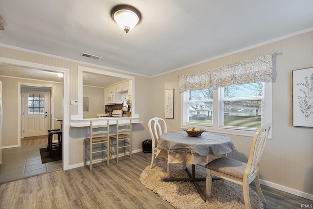 dining room with dark hardwood / wood-style floors and ornamental molding