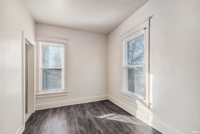 unfurnished room with dark hardwood / wood-style flooring and a wealth of natural light