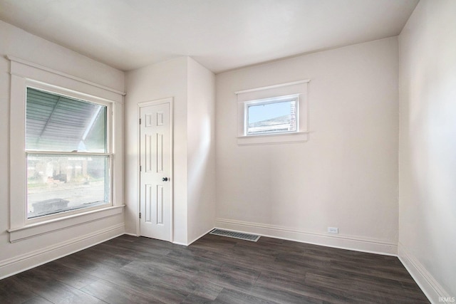 unfurnished room with dark wood-type flooring and a healthy amount of sunlight