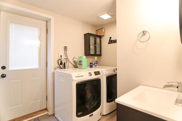 clothes washing area with dark hardwood / wood-style floors, washer and clothes dryer, and sink