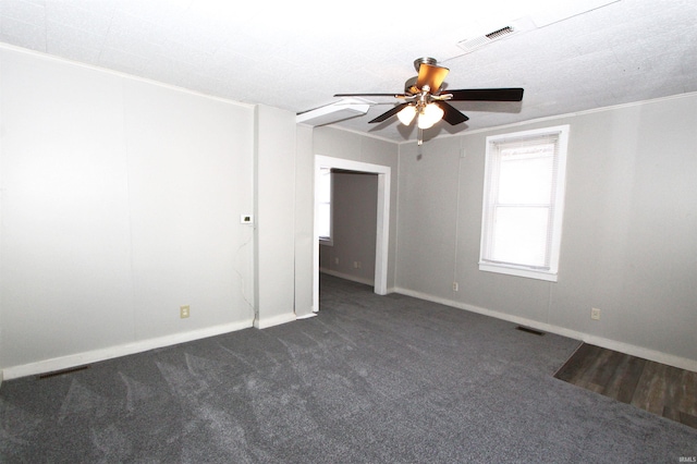 carpeted spare room with ceiling fan and crown molding