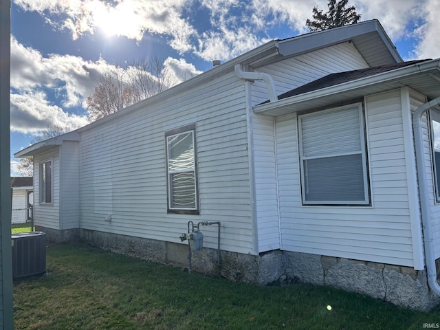 view of home's exterior with a lawn and cooling unit