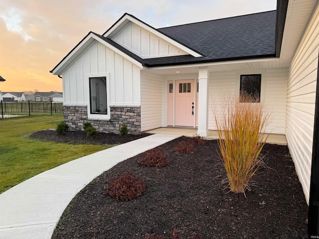 exterior entry at dusk featuring a lawn