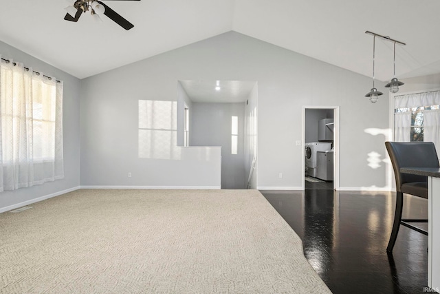 interior space with a wealth of natural light, ceiling fan, lofted ceiling, and washer / dryer