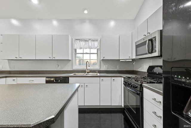 kitchen featuring dark tile patterned floors, sink, black appliances, white cabinets, and a center island