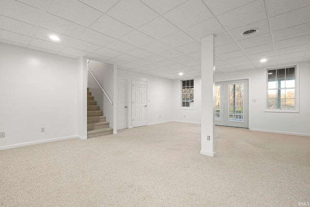 basement with a drop ceiling and light carpet