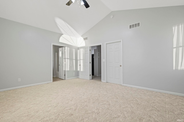 unfurnished bedroom with ceiling fan, light colored carpet, high vaulted ceiling, and multiple windows