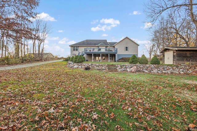 back of property featuring a lawn, a storage shed, and a wooden deck