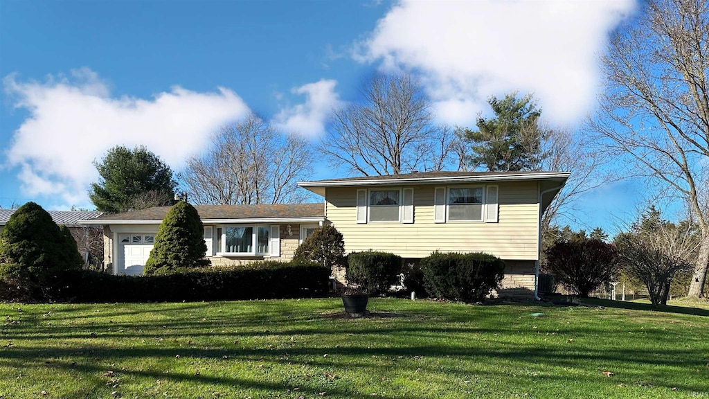 split level home with a front lawn and a garage