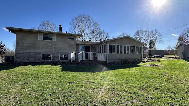 rear view of property featuring a lawn and a sunroom