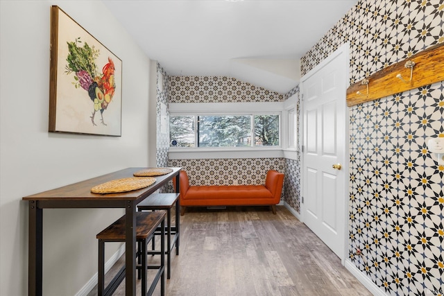 living area featuring lofted ceiling, wood-type flooring, and tile walls