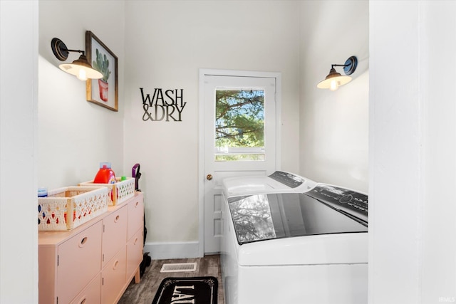 laundry room with cabinets, hardwood / wood-style floors, and washing machine and clothes dryer