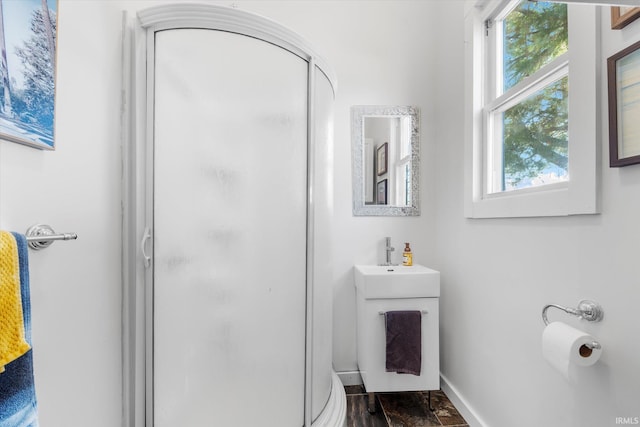 bathroom with hardwood / wood-style floors, vanity, and walk in shower