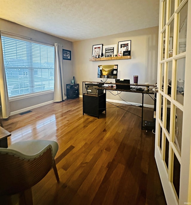 office space with dark hardwood / wood-style flooring, a textured ceiling, and french doors